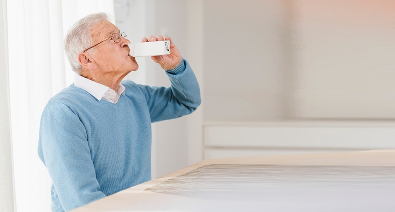 Elderly person drinking medical beverage