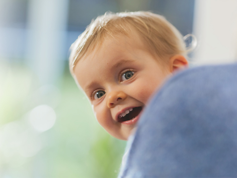 Infant girl looking over shoulder