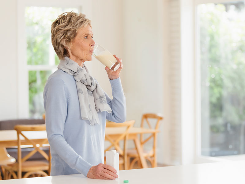 Elderly woman drinking medical beverage