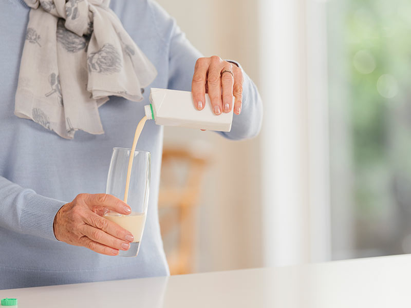 Elderly person pouring medical beverage